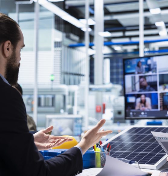Photovoltaics factory managers look over schematics during teleconference Photovoltaics factory admins look over schematics during internet video call, planning work inside facility. Solar panels plant engineers look over assembly lines blueprints in remote videoconference
